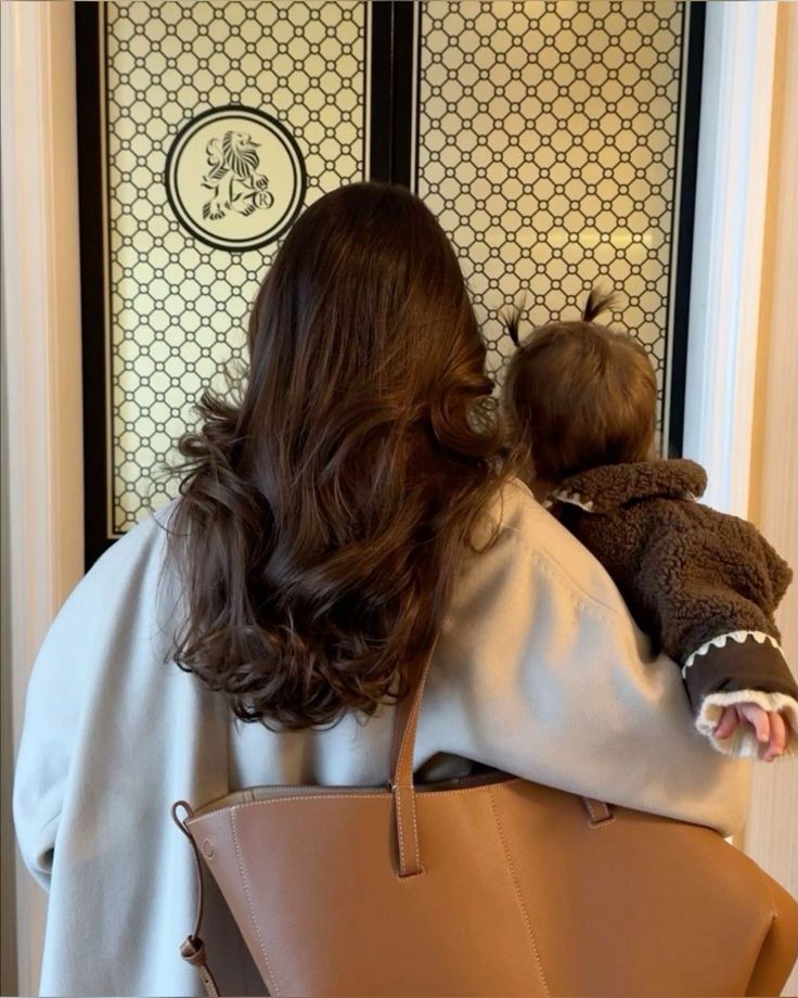 Beautiful mother with healthy hair holding her baby